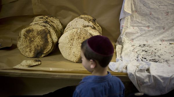 A boy looks at matzo, a traditional handmade Passover unleavened bread, that Jewish Orthodox bakers made in a bakery - Sputnik International