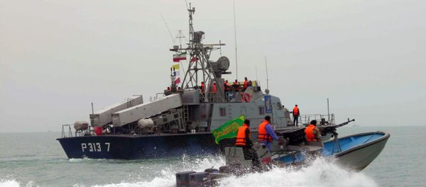 A picture released by the official Iranian News Agency shows members of Iran's elite Revolutionary Guard riding their boat along with an Iranian naval vessel during manoeuvers along the Gulf Sea and Sea of Oman, 03 April 2006 A picture released by the official Iranian News Agency shows members of Iran's elite Revolutionary Guard riding their boat along with an Iranian naval vessel during manoeuvers along the Gulf Sea and Sea of Oman, 03 April 2006 - Sputnik International