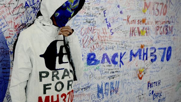 An unidentified woman wearing a mask depicting the flight of the missing Malaysia Airline, MH370, poses in front of the wall of hope at Kuala Lumpur International Airport in Sepang, Malaysia, Monday, March 17, 2014 - Sputnik International