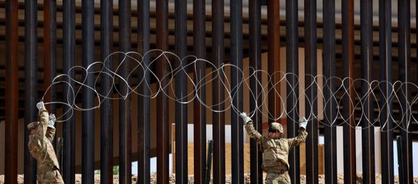 U.S. soldiers install concertina wire next to the border fence between Mexico and the United States, in El Paso, Texas, U.S., in this picture taken from Ciudad Juarez, Mexico, April 4, 2019 - Sputnik International