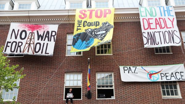 An activist in opposition of the U.S. involvement in Venezuela occupying the Venezuelan Embassy, sits in a window sill in Washington - Sputnik International