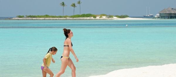 Unidentified foreign tourists walk along a beach of the Paradise Island Resort and Spa in the North Male' Atoll on February 14, 2012 - Sputnik International