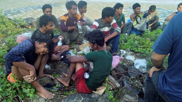Dozens of people, believed to be Rohingya Muslims from Myanmar who were dropped off from a boat are pictured on a beach near Sungai Belati, Perlis, Malaysia in this undated handout photo released April 8, 2019 - Sputnik International
