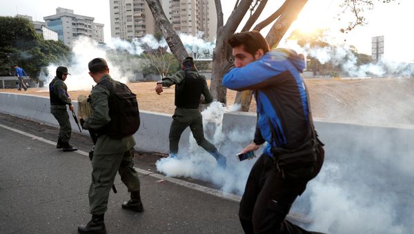 Military members react to tear gas, near the Generalisimo Francisco de Miranda Airbase La Carlota, in Caracas, Venezuela April 30, 2019 - Sputnik International
