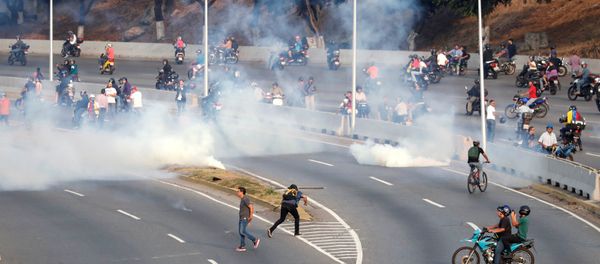 People react to tear gas near the Generalisimo Francisco de Miranda Airbase La Carlota, in Caracas, Venezuela April 30, 2019 People react to tear gas near the Generalisimo Francisco de Miranda Airbase La Carlota, in Caracas, Venezuela April 30, 2019 - Sputnik International