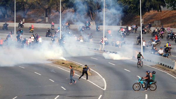People react to tear gas near the Generalisimo Francisco de Miranda Airbase La Carlota, in Caracas, Venezuela April 30, 2019 - Sputnik International