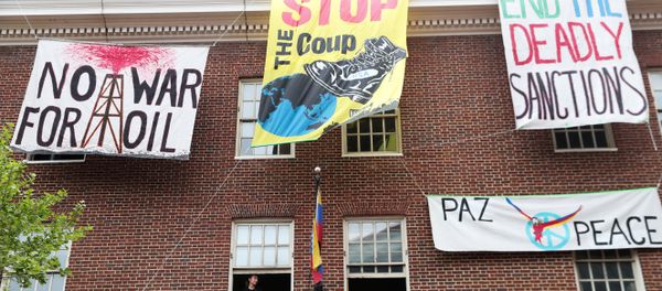 An activist in opposition of the U.S. involvement in Venezuela occupying the Venezuelan Embassy, sits in a window sill in Washington, U.S., April 25, 2019. - Sputnik International