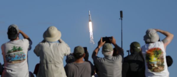 Visitors at Playalinda Beach look on as a SpaceX Falcon Heavy rocket launches from Pad 39B at the Kennedy Space Center in Florida, on April 11, 2019 - Sputnik International