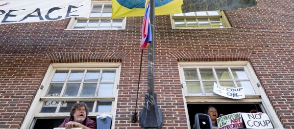 Pro Nicolas Maduro supporters look out the windows of the Venezuelan Embassy in Washington, Thursday, May 2, 2019. Pro interim government opposition leader Juan Guaido supporters have blocked the entrances to the embassy, cutting off supplies to pro Nicolas Maduro supporters occupying the building. Pro Nicolas Maduro supporters look out the windows of the Venezuelan Embassy in Washington, Thursday, May 2, 2019. Pro interim government opposition leader Juan Guaido supporters have blocked the entrances to the embassy, cutting off supplies to pro Nicolas Maduro supporters occupying the building. - Sputnik International
