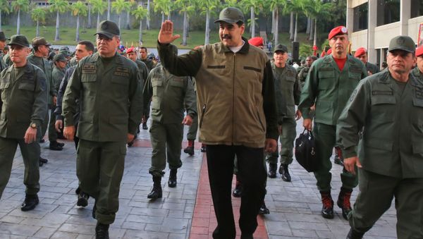 Venezuela's President Nicolas Maduro waves as he walks next to Venezuela's Defense Minister Vladimir Padrino Lopez and Remigio Ceballos, Strategic Operational Commander of the Bolivarian National Armed Forces, during a ceremony at a military base in Caracas, Venezuela May 2, 2019 - Sputnik International
