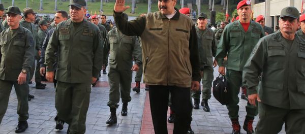 Venezuela's President Nicolas Maduro waves as he walks next to Venezuela's Defense Minister Vladimir Padrino Lopez and Remigio Ceballos, Strategic Operational Commander of the Bolivarian National Armed Forces, during a ceremony at a military base in Caracas, Venezuela May 2, 2019 - Sputnik International