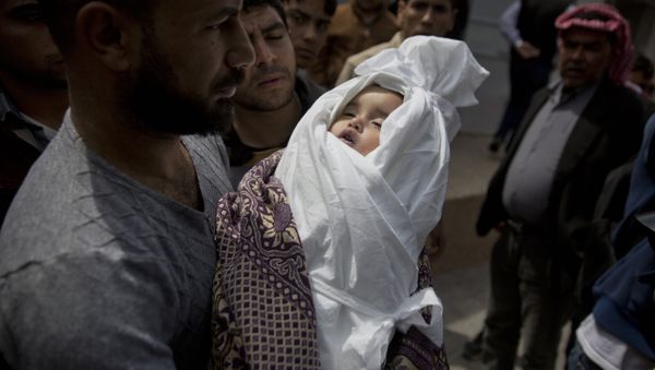 A relative of a Palestinian, 14-month-old, Seba Abu Arar, carry her body out of the Shifa hospital morgue before her funeral in Gaza City, Sunday, May. 5, 2019. Gaza's Health Ministry said the Palestinian infant was killed when Israeli aircraft hit near her house - Sputnik International