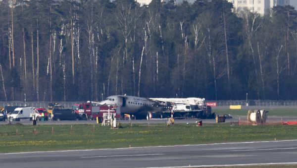 The Sukhoi SSJ100 aircraft of Aeroflot Airlines, center in the background, is seen after an emergency landing in Sheremetyevo airport outside Moscow, Russia, Monday, May 6, 2019 - Sputnik International