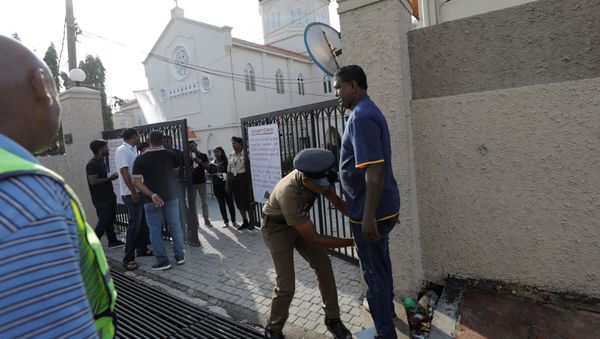 A police officer searches a worshipper at the main entrance of the St.Theresa's church as the Catholic churches in Sri Lanka restart their Sunday service after Easter Sunday bombing attacks on 21st of April,in Colombo, Sri Lanka May 12, 2019 - Sputnik International