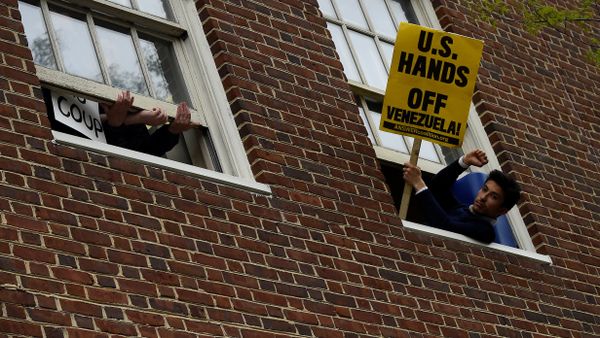 A man holds a sign outside the window of the Venezuelan embassy which is occupied by Nicolas Maduro supporters as Venezuelan opposition leader Juan Guido's envoy to the United States Carlos Vecchio speaks outside in Washington, U.S., May 1, 2019 A man holds a sign outside the window of the Venezuelan embassy which is occupied by Nicolas Maduro supporters as Venezuelan opposition leader Juan Guido's envoy to the United States Carlos Vecchio speaks outside in Washington, U.S., May 1, 2019 - Sputnik International