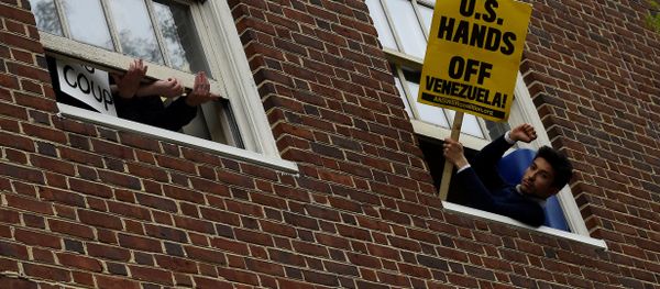 A man holds a sign outside the window of the Venezuelan embassy which is occupied by Nicolas Maduro supporters as Venezuelan opposition leader Juan Guido's envoy to the United States Carlos Vecchio speaks outside in Washington, U.S., May 1, 2019 A man holds a sign outside the window of the Venezuelan embassy which is occupied by Nicolas Maduro supporters as Venezuelan opposition leader Juan Guido's envoy to the United States Carlos Vecchio speaks outside in Washington, U.S., May 1, 2019 - Sputnik International