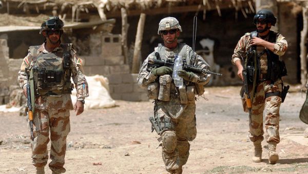 U.S. Army Capt. Eric Morton, center, commander of the 101st Airborne Division's Company B, 1st Battalion, 35th Armor Regiment, walks with Iraqi Maj. Ahmed Hassan and Iraqi 1st Lt. Yasev Mutasam through Shakriyah, Iraq, area during Operation New Town, June 10, 2008 - Sputnik International