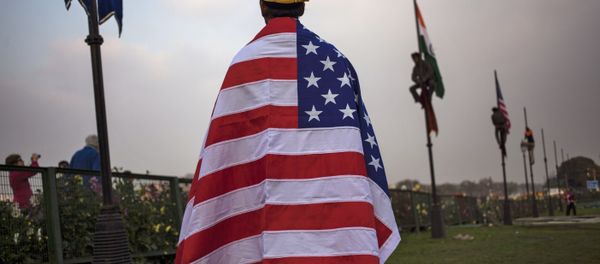 An Indian worker wears an American flag before it is hoisted up a flag pole in New Delhi, India, Friday, Jan. 23, 2015 An Indian worker wears an American flag before it is hoisted up a flag pole in New Delhi, India, Friday, Jan. 23, 2015 - Sputnik International