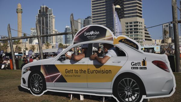 People pose in a cutout taxi cab ahead of the 2019 Eurovision Song Contest in Tel Aviv, Israel, Monday, May 13, 2019 - Sputnik International
