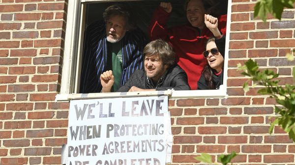 The four activists inside the Venezuelan embassy in Washington look outside the window from a second floor on Tuesday, May 14, 2019. Clockwise from left: Kevin Zeese, Margaret Flowers, Adrienne Pine, and David Paul. - Sputnik International
