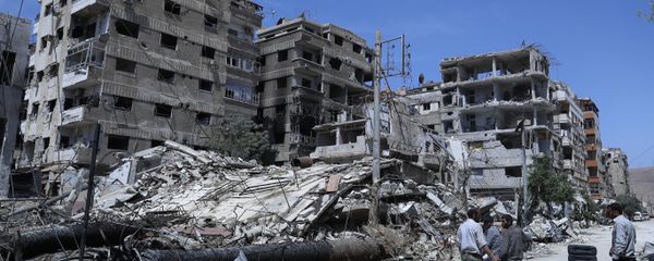 People stand in front of damaged buildings, in the town of Douma, the site of a suspected chemical weapons attack, near Damascus, Syria, Monday, April 16, 2018 - Sputnik International