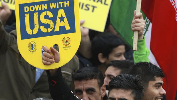 A demonstrator holds an anti-U.S. placard during a ceremony celebrating the 40th anniversary of the Islamic Revolution, at the Azadi, Freedom, Square in Tehran, Iran, Monday, Feb. 11, 2019 - Sputnik International