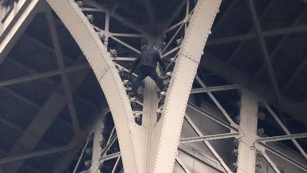 A climber is pictured between two iron columns of the Eiffel Tower Monday, May 20, 2019 in Paris - Sputnik International