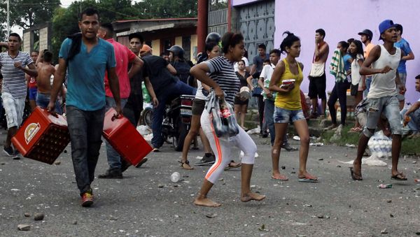 People carry goods taken from a food wholesaler after it was broken into, in La Fria, Venezuela December 17, 2016. REUTERS/Carlos Eduardo Ramirez People carry goods taken from a food wholesaler after it was broken into, in La Fria, Venezuela December 17, 2016. REUTERS/Carlos Eduardo Ramirez - Sputnik International