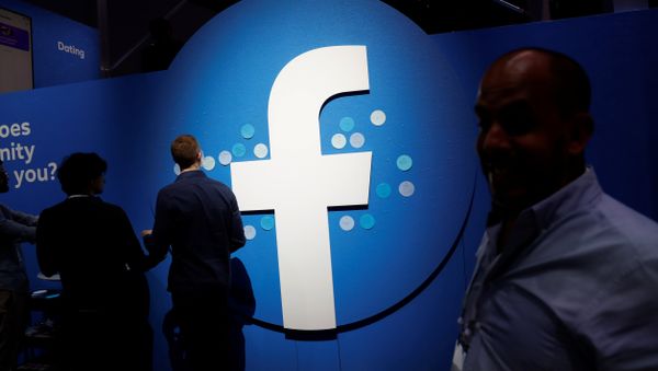 Attendees walk past a Facebook logo during Facebook Inc's F8 developers conference in San Jose, California, U.S., April 30, 2019 - Sputnik International