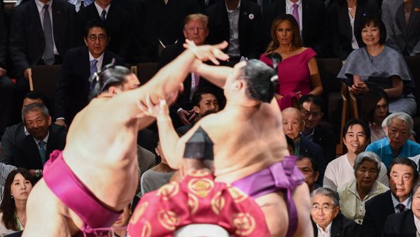 Japan's Prime Minister Shinzo Abe (centre L) and his wife Akie Abe (centre R) accompany US President Donald Trump (C) and First Lady Melania Trump (C Red dress) as they arrive to watch the Summer Grand Sumo Tournament in Tokyo on May 26, 2019. - Sputnik International