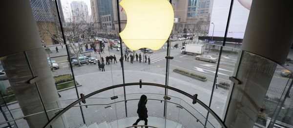 A customer walks under an Apple logo sign at an Apple shop in Shanghai on February 22, 2012 A customer walks under an Apple logo sign at an Apple shop in Shanghai on February 22, 2012 - Sputnik International