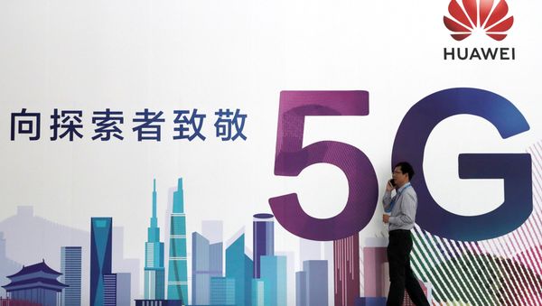 A man talks on his mobile phone beside Huawei's billboard featuring 5G technology at the PT Expo in Beijing, China, September 26, 2018 - Sputnik International