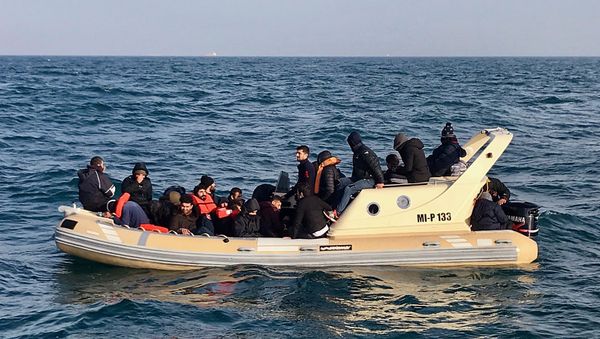 A handout image made available by France's Societe Nationale de Sauvetage en Mer (SNSM) on February 18, 2019, shows British rescuers (front) helping some 20 migrants on a semi-rigid boat trying make their way from France across the English Channel - Sputnik International
