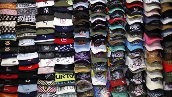 Caps made in China are sold at a local market in Beijing, China, Tuesday, March 31, 2009. Chinese exporters have seen global demands for their products plunge, leaving companies to dump goods in to a domestic market that is not as robust as foreign markets. The Chinese government has pushed forward a stimulus package that hopes to reduce the reliance on exports by increasing the domestic demand for goods. (AP Photo/ Elizabeth Dalziel) - Sputnik International