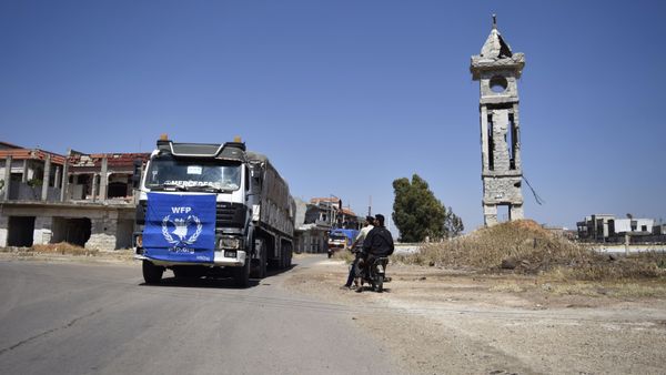 An aid truck of the UN World Food Programm (WFP) drives past destroyed buildings the town of Al-Houla, on the northern outskirts of Homs in central Syria, on May 25, 2016 - Sputnik International