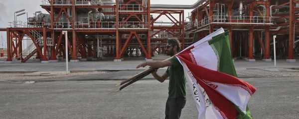 An Iranian worker carries Iranian flags prior to an inauguration ceremony of a natural gas refinery at the South Pars gas field on the northern coast of the Persian Gulf, in Asaluyeh, Iran An Iranian worker carries Iranian flags prior to an inauguration ceremony of a natural gas refinery at the South Pars gas field on the northern coast of the Persian Gulf, in Asaluyeh, Iran - Sputnik International