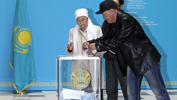 A member of an election commission helps an elderly Kazakh woman to cast her ballot at a polling station in Astana A member of an election commission helps an elderly Kazakh woman to cast her ballot at a polling station in Astana - Sputnik International