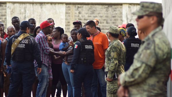 Migrants talk to police officers as soldiers, assigned to the newly created National Guard, keep watch outside the Siglo XXI immigrant detention center as part of the security measures by the federal government, in Tapachula, Mexico May 23, 2019. REUTERS/Jose Torres - Sputnik International