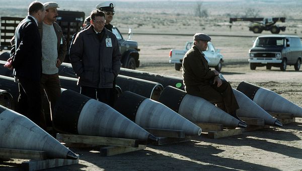 Soviet inspectors and their American escorts stand among several dismantled Pershing II missiles as they view the destruction of other missile components - Sputnik International