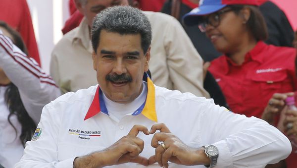 In this 20 May 2019 photo, Venezuela's President Nicolas Maduro flashes a hand-heart symbol to supporters outside Miraflores presidential palace in Caracas, Venezuela. - Sputnik International