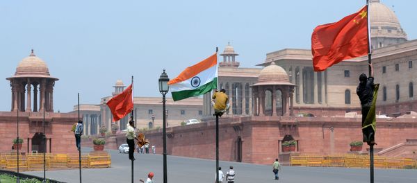 Indian workers tie Indian and Chinese national flags onto poles in front of The Indian Secretariat in New Delhi on May 18, 2013 - Sputnik International
