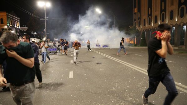 People flee as riot policemen use tear gas during a protest against a Russian lawmaker's visit outside the parliament building in Tbilisi, Georgia June 20, 2019 - Sputnik International