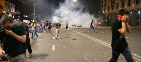 People flee as riot policemen use tear gas during a protest against a Russian lawmaker's visit outside the parliament building in Tbilisi, Georgia June 20, 2019 - Sputnik International