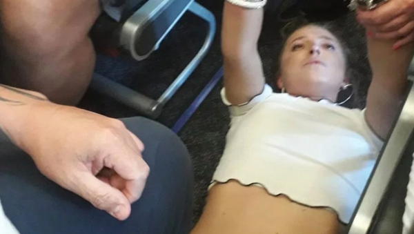 Woman arrested after trying to open airplane door mid-flight - Sputnik International