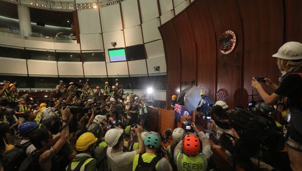Protesters tie the British colonial flag to the parliament's podium after breaking into the government headquarters in Hong Kong on 1 July 2019, on the 22nd anniversary of the city's handover from Britain to China. - Sputnik International