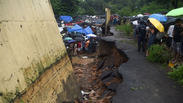 Rescue workers and onlookers gather at the site of a wall collapse in Mumbai on July 2, 2019 - Sputnik International