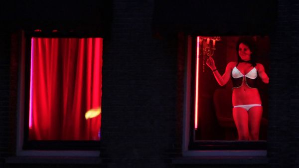 In this photo taken Monday Jan. 10, 2011 a prostitute advertises her wares behind red-lit windows in Amsterdam, Netherlands - Sputnik International