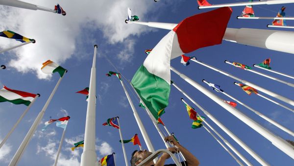 A worker hoists Italy's flag along with the flags of the European Union and African countries participating in the EU-Africa summit Friday, Dec. 7, 2007, in Lisbon - Sputnik International