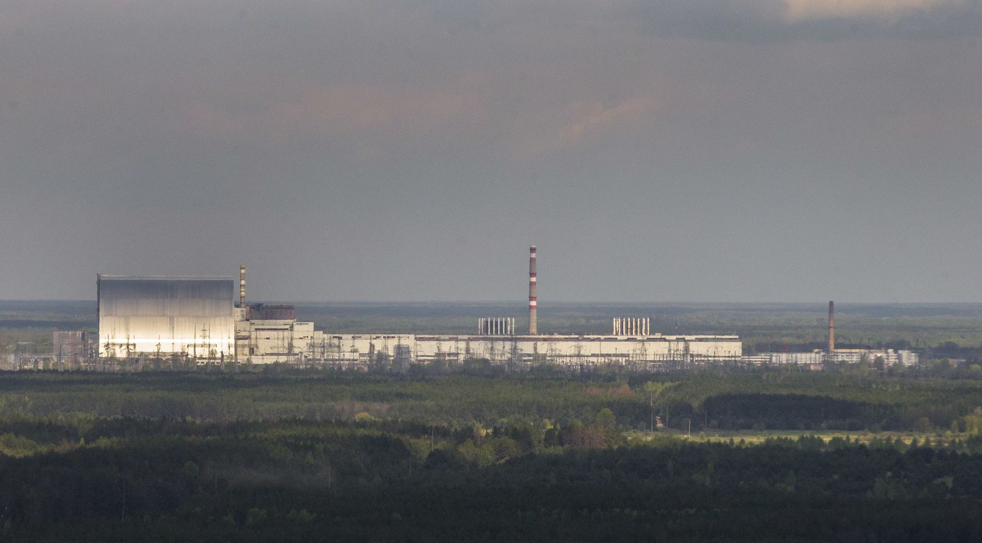 An aerial view of the Chernobyl nuclear power plant and a new shelter, left, installed over the exploded reactor at the Chernobyl nuclear plant, in Chernobyl, Ukraine, Thursday, April 26, 2018. - Sputnik International, 1920, 04.02.2022