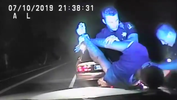 James Myron Mitchell, handcuffed, has his arms pulled back and head forced down on the hood of a Hamilton County Sheriff's Office cruiser as one officer conducts a cavity search that is being called unlawful by Mitchell's lawyer, July 10, 2019,  - Sputnik International